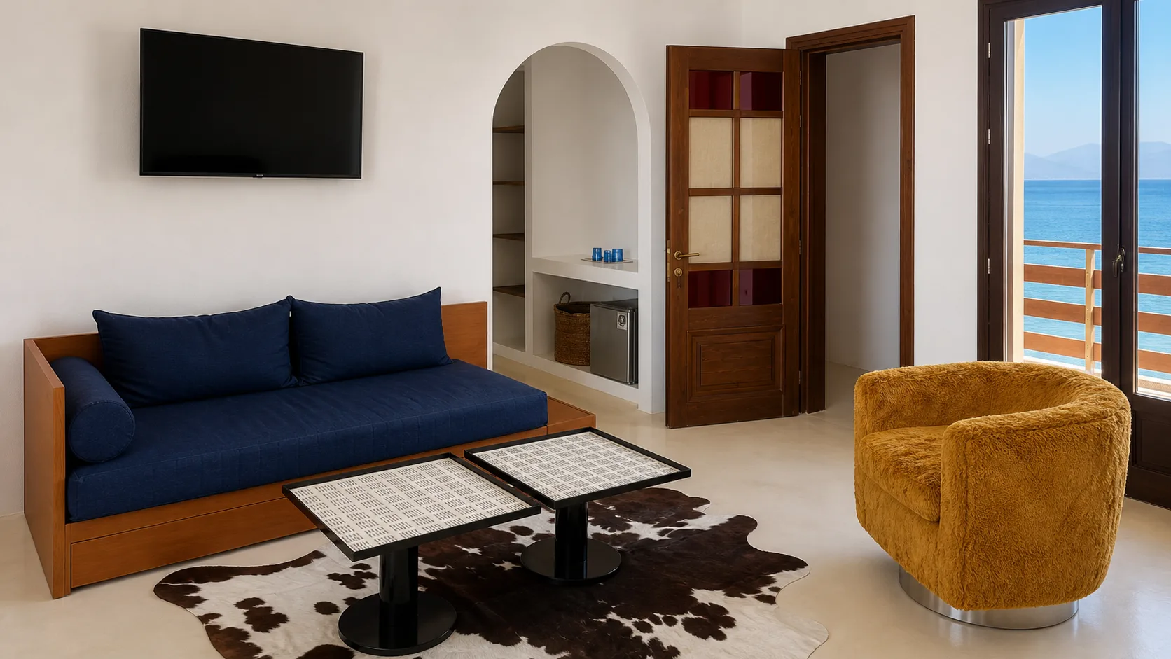 Ocean-view suite lounge with blue sofa and ochre chair
